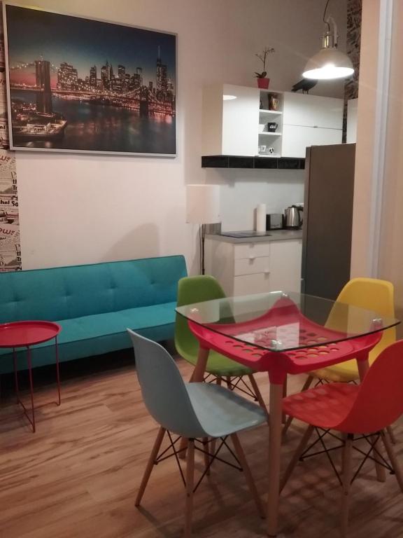 un salon avec une table, des chaises et un canapé dans l'établissement Apartament Pod Wroną, à Toruń
