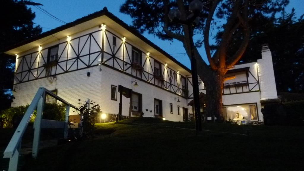 een wit huis met lichten aan de zijkant bij Hosteria Actinia in Villa Gesell