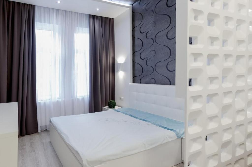 リヴィウにあるСтильні апартаменти Львів Центрの白いベッドルーム(ベッド1台、鏡付)