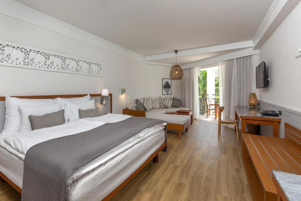 ein Schlafzimmer mit großem Bett und ein Wohnzimmer in der Unterkunft Sunwing Bangtao Beach in Strand Bang Tao