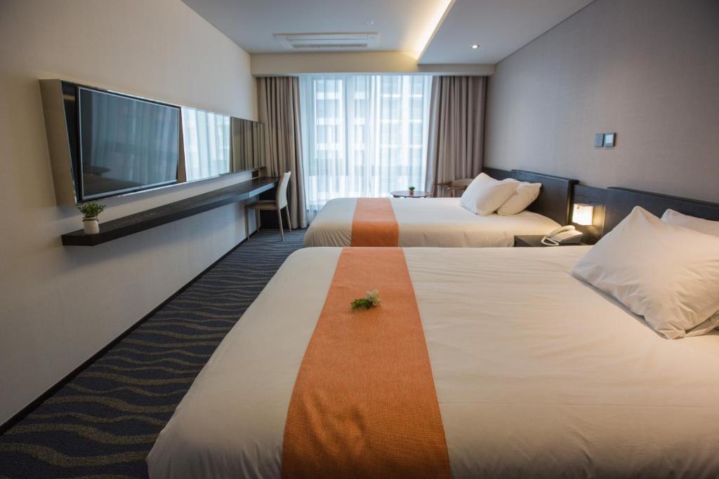 Postel nebo postele na pokoji v ubytování Gloucester Hotel Jeju
