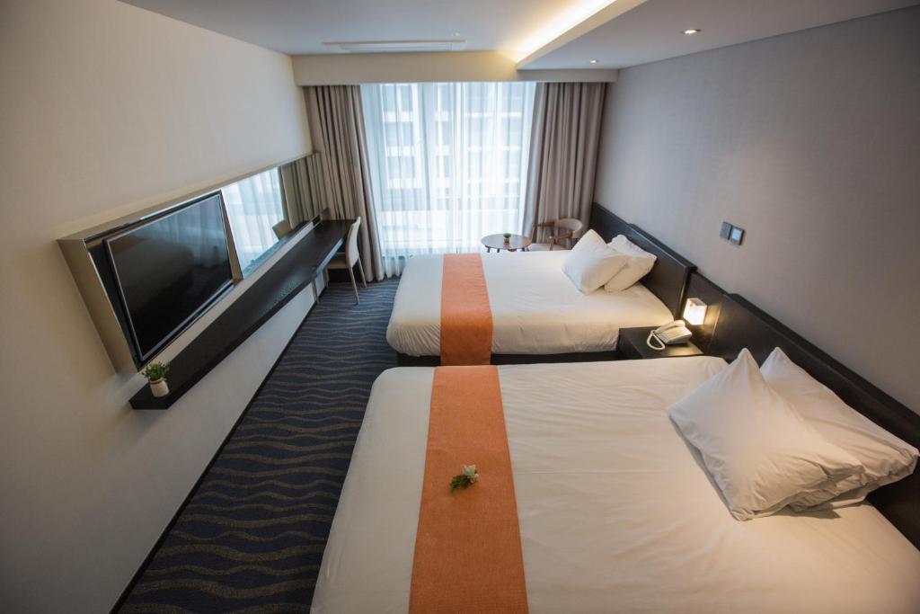 Postel nebo postele na pokoji v ubytování Gloucester Hotel Jeju