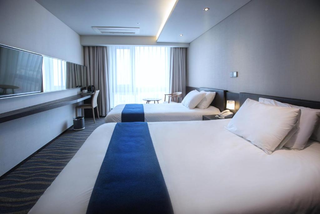 Postel nebo postele na pokoji v ubytování Gloucester Hotel Jeju