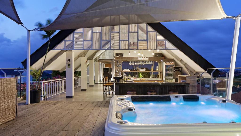 a hot tub on the deck of a house at Hotel Daun Bali Seminyak in Seminyak