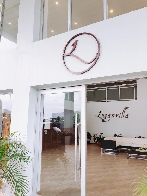 ルーガンビルにあるLuganvilla Business Hotel and Restaurantの建物脇の現代売店の看板