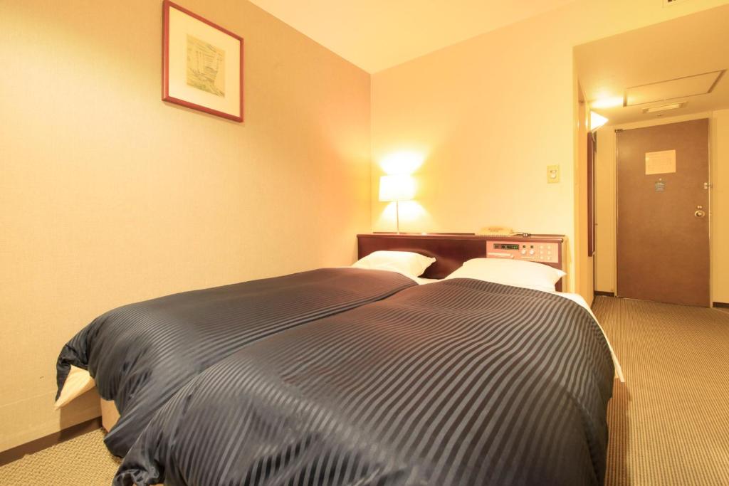 Postel nebo postele na pokoji v ubytování Quintessa Hotel Ogaki