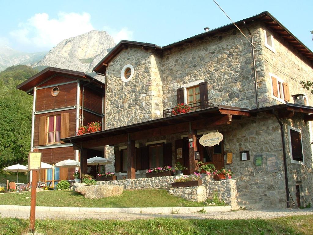 un gran edificio de piedra con una montaña en el fondo en Locanda del Sorriso, en Entracque