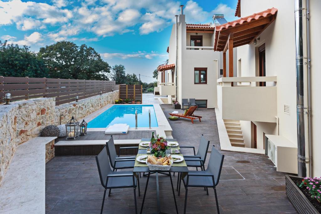 a patio with a table and chairs next to a swimming pool at All Seasons Villas in Gállos