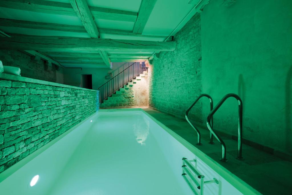 a bathroom with a bath tub with blue lighting at Abbaye de Maizières in Beaune
