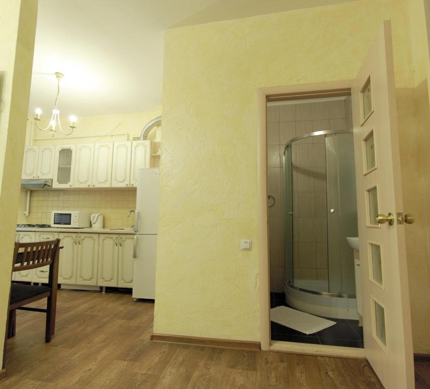a kitchen with white cabinets and a glass door at Studio on Sobornaya in Mykolaiv