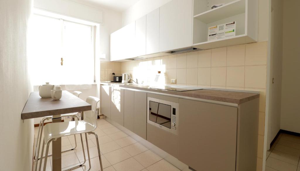 une cuisine blanche avec un comptoir et une table dans l'établissement Italianway-Bergognone 47 Flat, à Milan