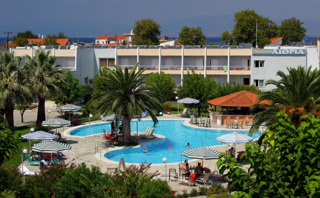 a large swimming pool with umbrellas in a resort at Hotel Aethria in Limenas