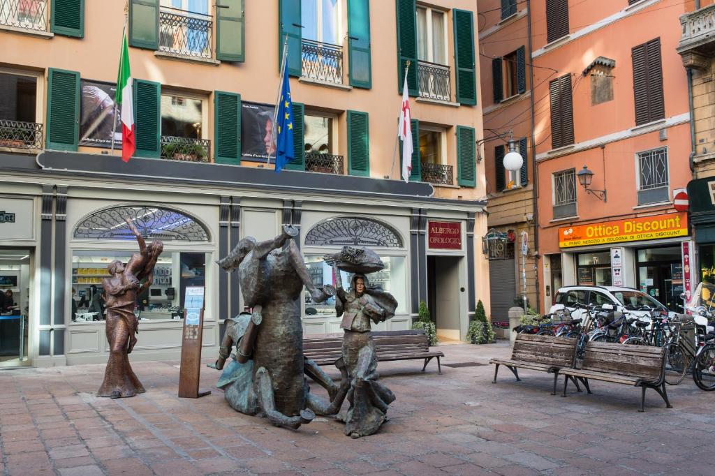 a statue of three people with umbrellas on a street at Art Hotel Orologio in Bologna