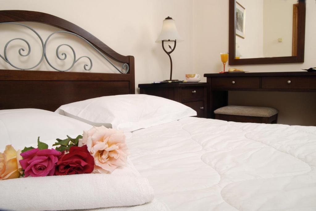 a bedroom with a white bed with flowers on it at Xenonas Chrisso in Delfoi