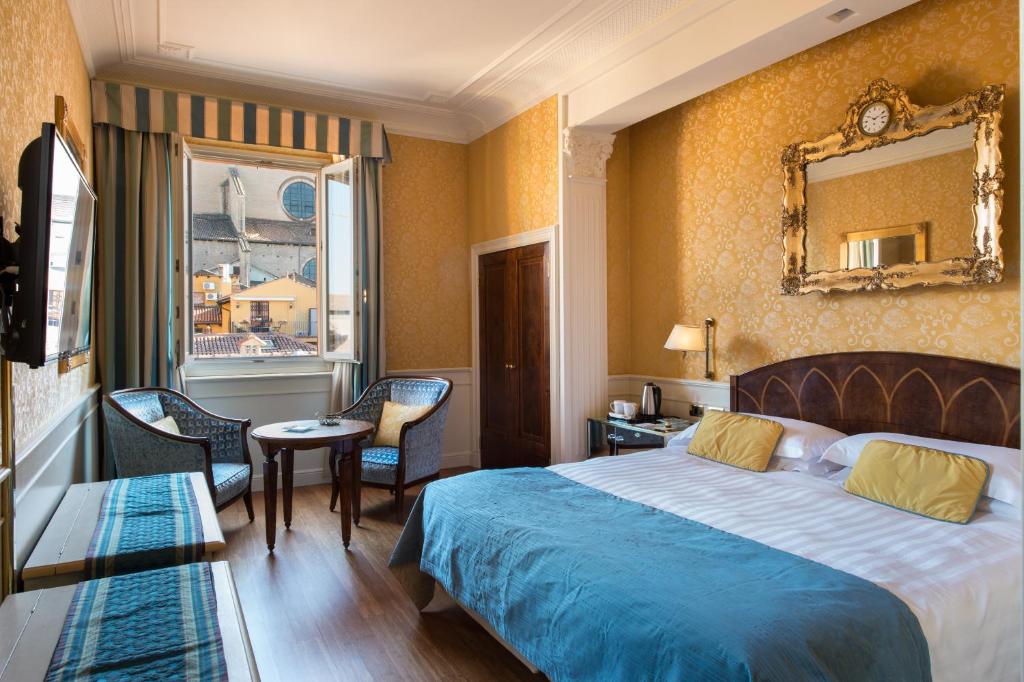 ボローニャにあるアート  ホテル オロロージョのベッドと鏡が備わるホテルルーム