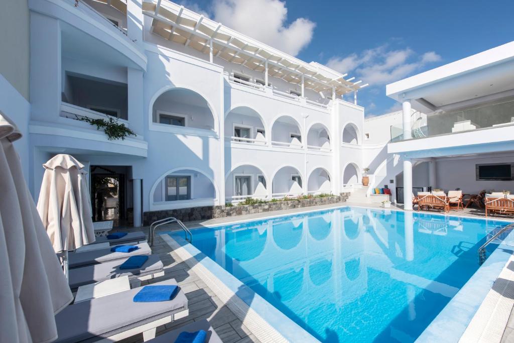 Villa con piscina y sillas en Blue Waves Suites & Apartments en Kamari