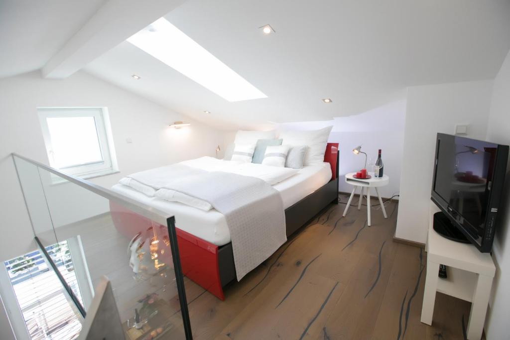 een witte slaapkamer met een bed en een televisie bij Haus am Weinberg in Seekirchen am Wallersee