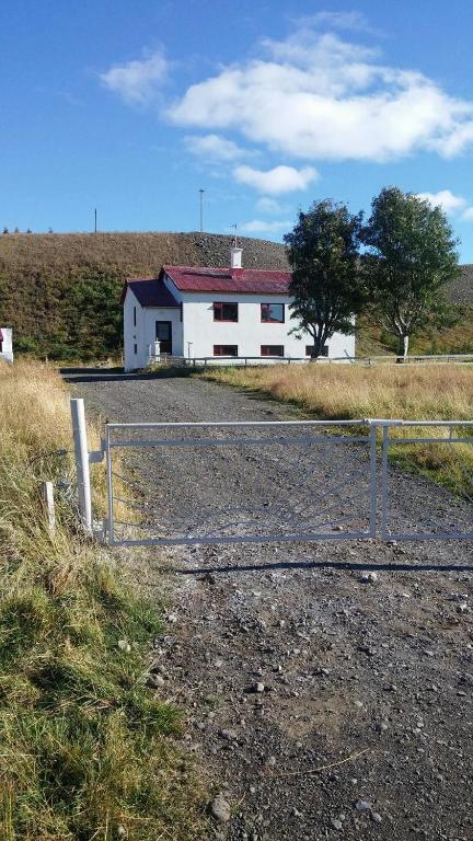 a white building in the middle of a field at Thorbrandsstadir Farm Holidays in Þorbrandsstaðir
