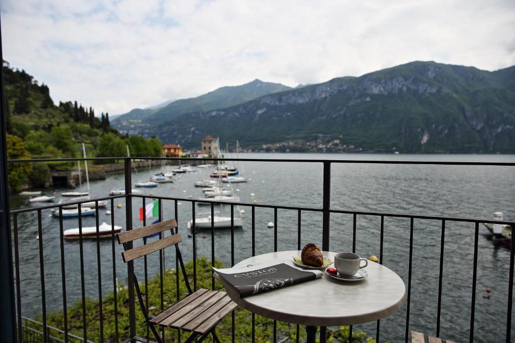 a table on a balcony with a view of a lake at Locanda La Pergola in Bellagio