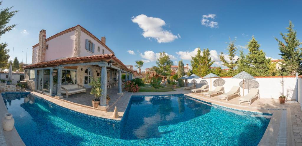 a house with a swimming pool and a house at Moy Hotel in Alacati