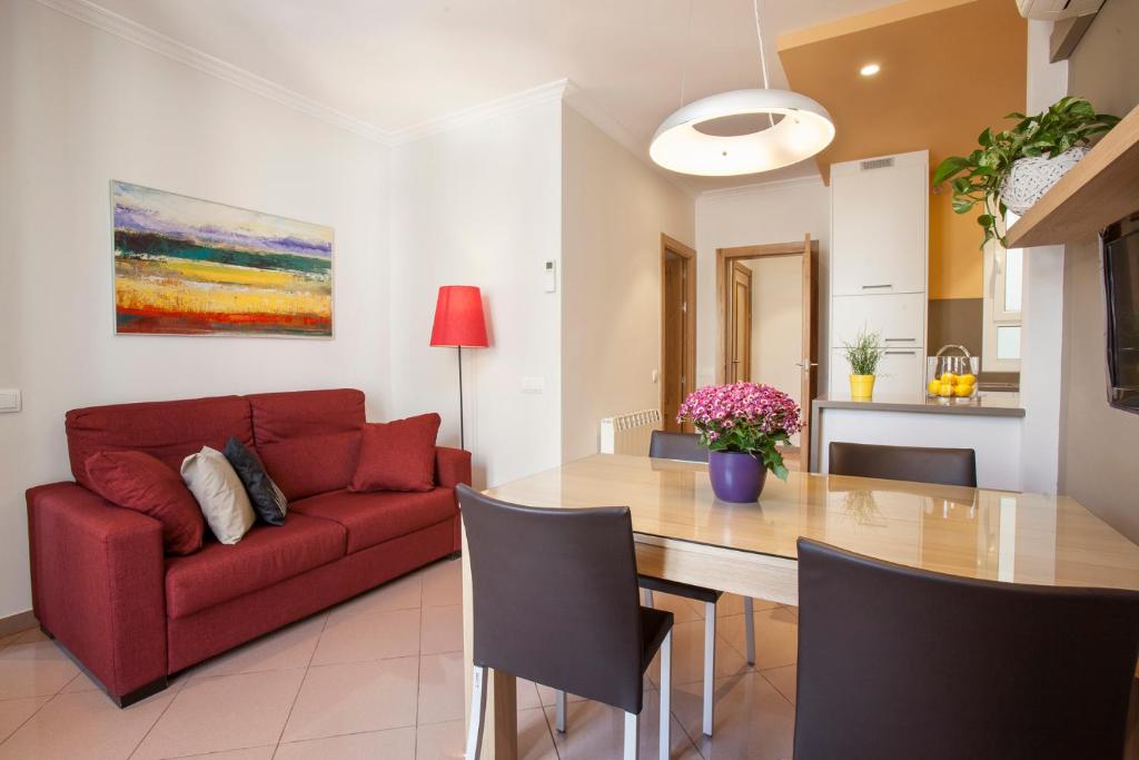 a living room with a red couch and a table at BCNGOTIC 22 in Barcelona