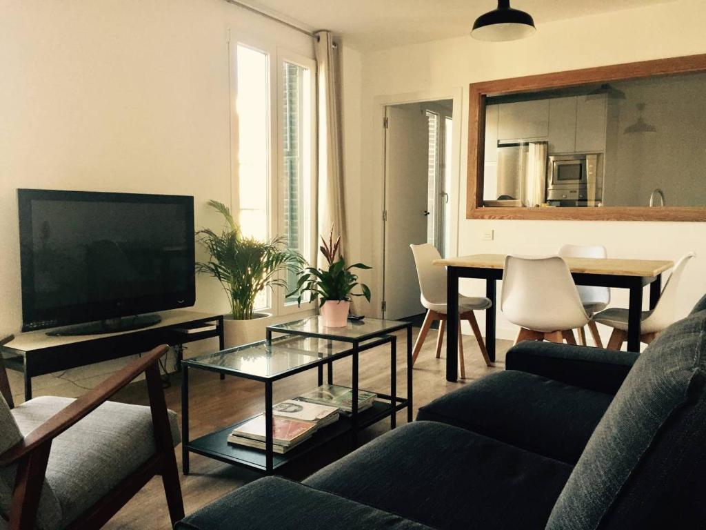 マドリードにあるCharming and bright apartmentのリビングルーム(ソファ、テレビ、テーブル付)