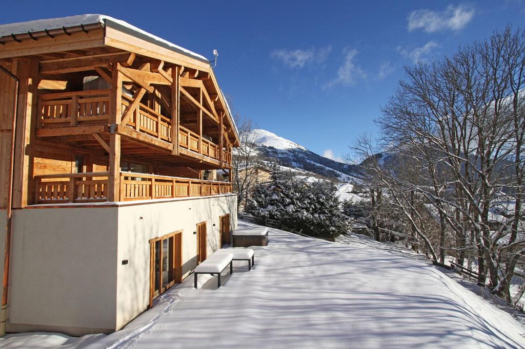 un edificio con panchine su un marciapiede coperto da neve di Odalys Chalet Nuance de blanc a LʼAlpe-dʼHuez