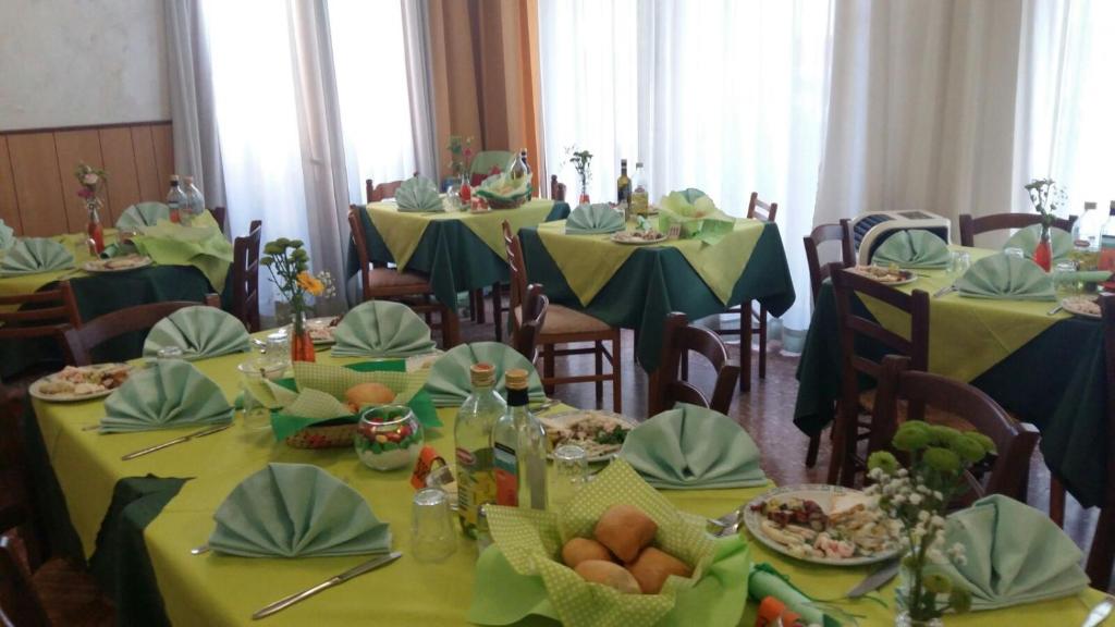 uma sala de jantar com mesas com mesas amarelas e verdes em Hotel Taormina em Lido di Jesolo
