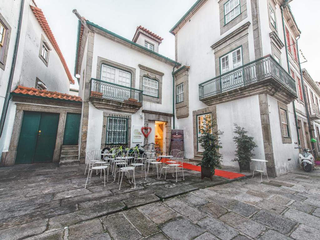 un patio avec des tables et des chaises en face d'un bâtiment dans l'établissement Maçã de Eva, à Viana do Castelo