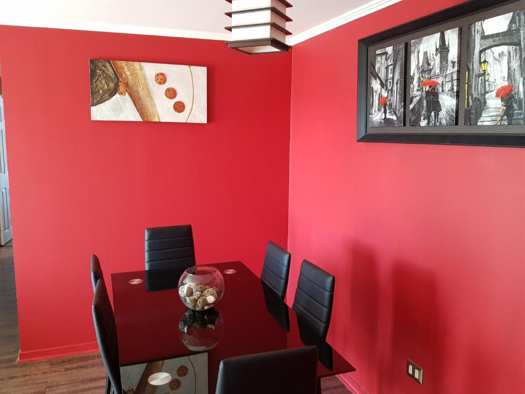 comedor con paredes rojas, mesa y sillas en Home Apartments, en Los Ángeles