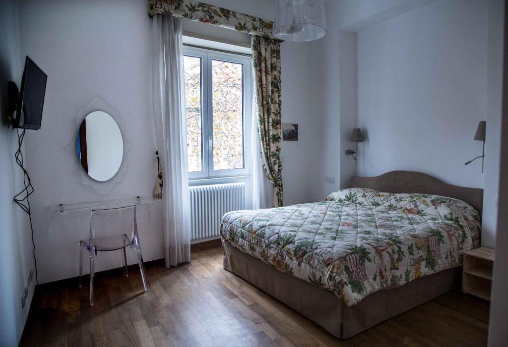 ローマにあるCasa con Terrazzino Trastevereのベッドルーム1室(ベッド1台、鏡、窓付)