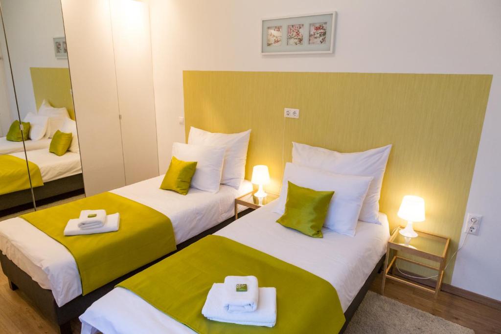 布達佩斯的住宿－巴拉頓湖豪華公寓，黄色和绿色的客房内的两张床