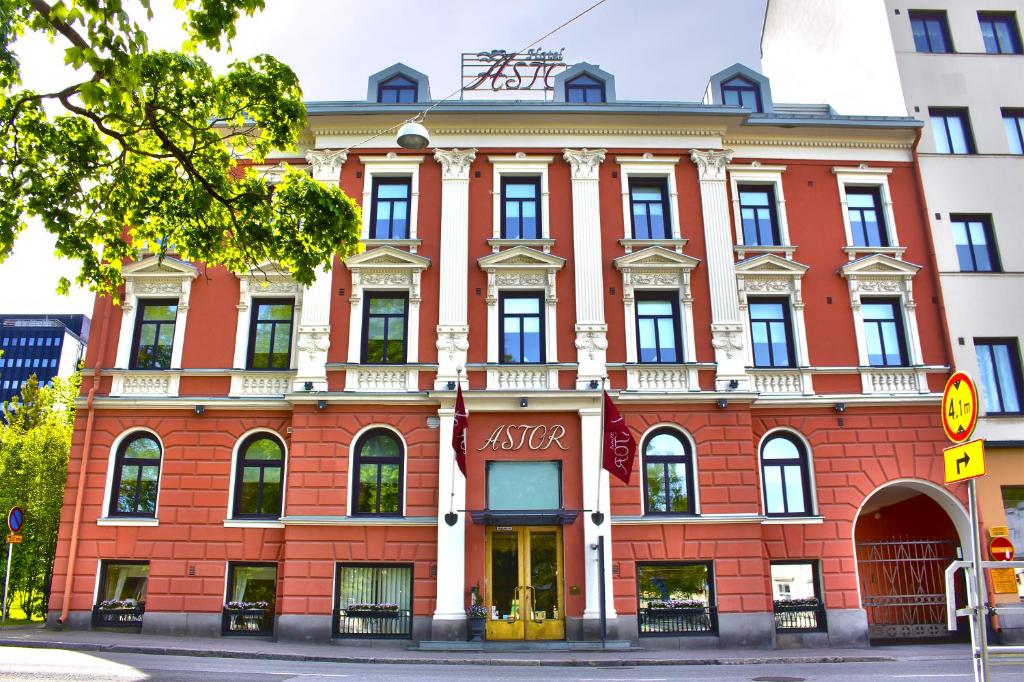 un edificio de ladrillo rojo en la esquina de una calle en Hotel Astor, en Vaasa