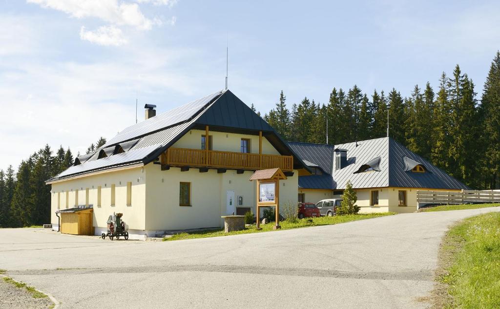 un gran edificio blanco con techo negro en EA Horský Hotel Hájenka, en Modrava