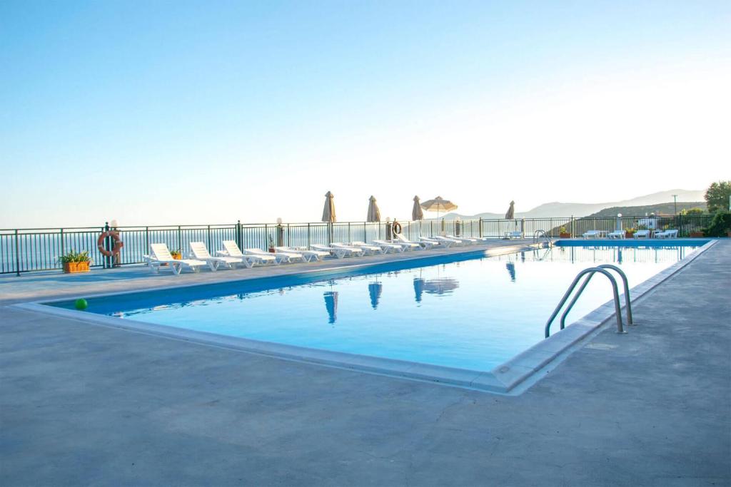 a large swimming pool with chairs and people in the background at Saint Catherine Hotel in Pythagoreio