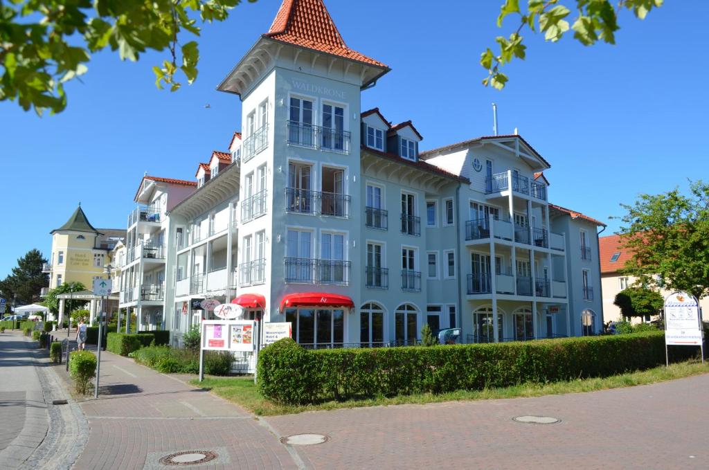 ein großes Gebäude mit einem Turm auf einer Straße in der Unterkunft Ferienappartement und Economyzimmer Residenz Waldkrone in Kühlungsborn