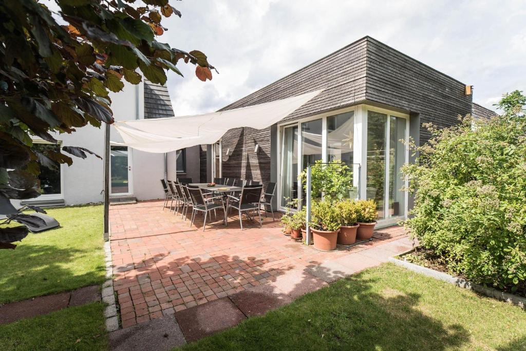 Cette maison dispose d'une terrasse avec une table et des chaises. dans l'établissement Refugium-Luebeck, à Lübeck