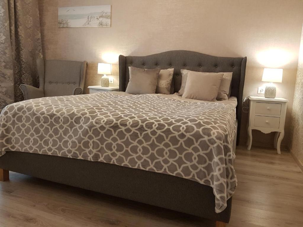 2 Bedroom Lux Apartments في ريغا: غرفة نوم بسرير كبير وموقف ليلتين