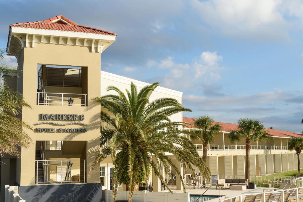 a building with a palm tree in front of it at Marker 8 Hotel and Marina in Saint Augustine