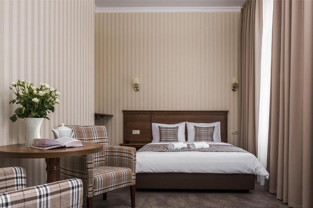 モスクワにあるDetol Hotelのベッドルーム1室(ベッド1台、テーブル、椅子付)