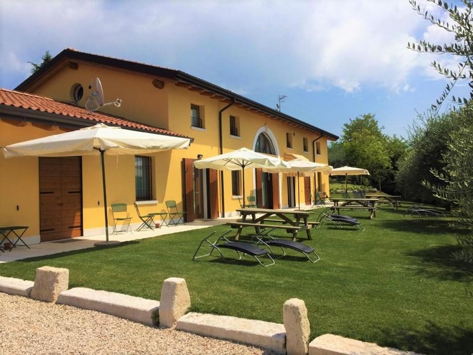 a building with tables and chairs and umbrellas at Al Vajo Dependance - Apartments-Zimmer in Lazise