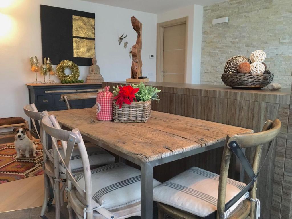 uma mesa de jantar com 2 cadeiras e uma mesa com decorações em A casa di Romeo em Madesimo