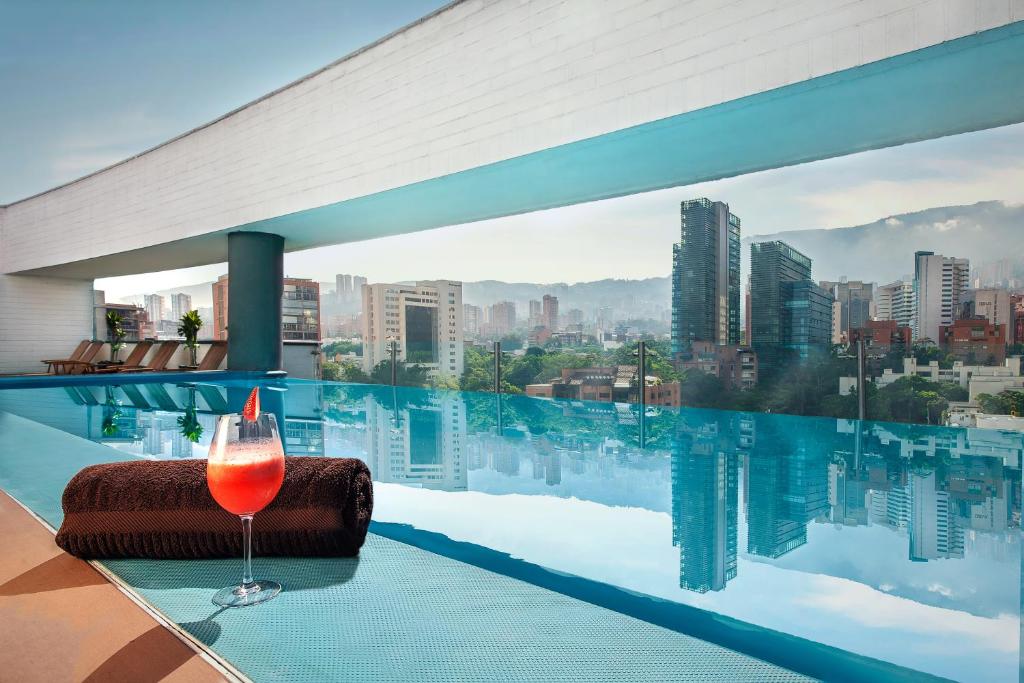 una copa de vino sentada en una mesa frente a una ventana en Sites Hotel, en Medellín