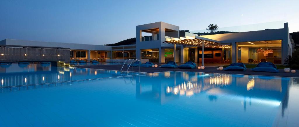 uma grande piscina em frente a uma casa em Thalatta Seaside Hotel em Ayia anna