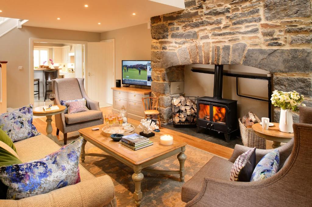 a living room with a fireplace and a stone wall at The Hawthorn in Doolin