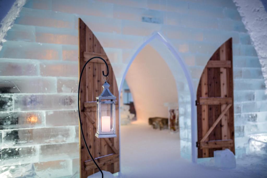 a lantern hanging on a wall next to two doors at Hotel de Glace in Saint-Gabriel-De-Valcartier