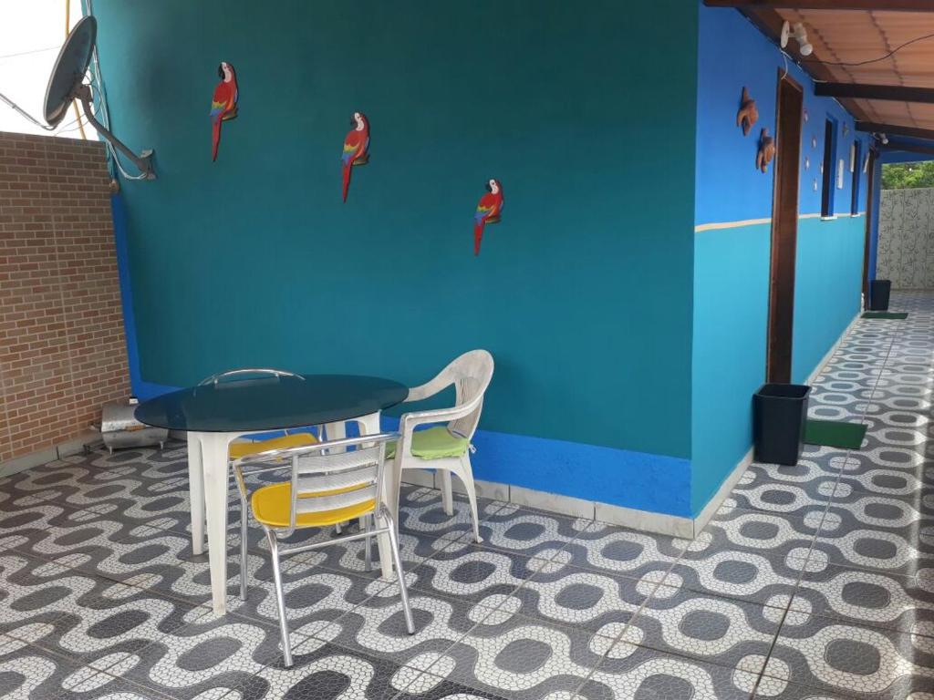 una mesa y dos sillas junto a una pared azul en Kitnet Rio Vermelho, en Salvador