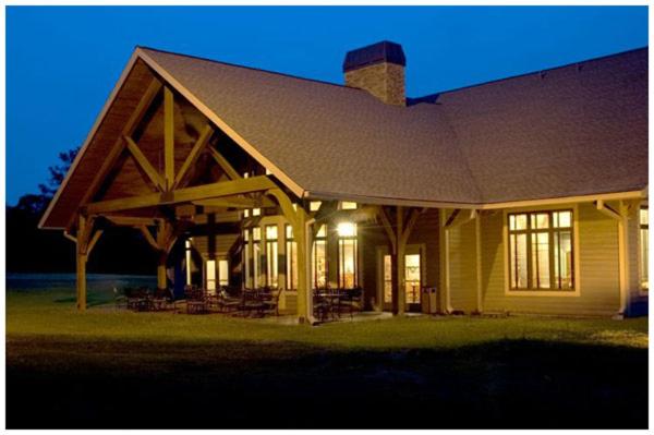 una casa con techo de gambrel con luces encendidas en Little Ocmulgee State Park and Lodge en McRae