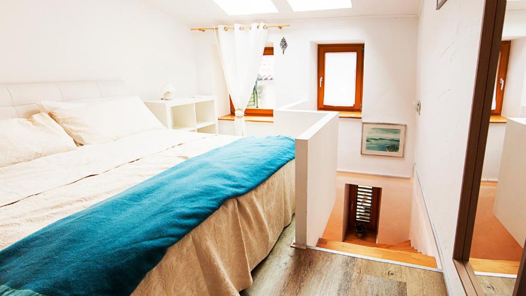 a bedroom with a bed with a blue blanket on it at Apartment Alex in Piran
