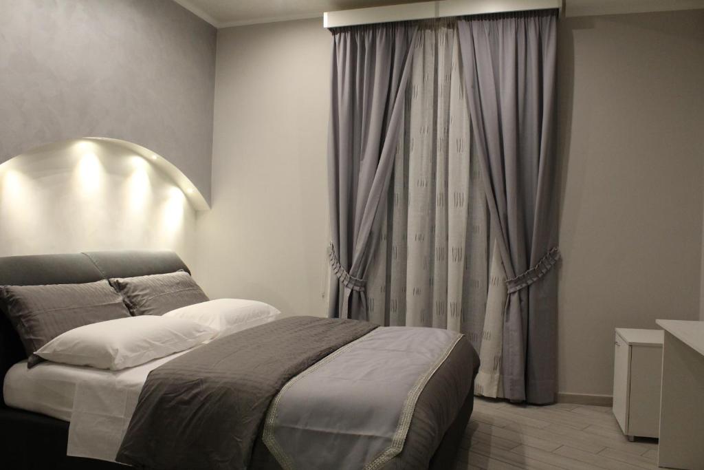 ナポリにあるB&B Fiumaraのベッドルーム1室(ベッド1台付)、窓(カーテン付)